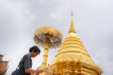 Asyalı adam seyahat eder ve yaz mevsiminde Chiangmai Tayland 'daki altın tapınağa fotoğraf çeker.
