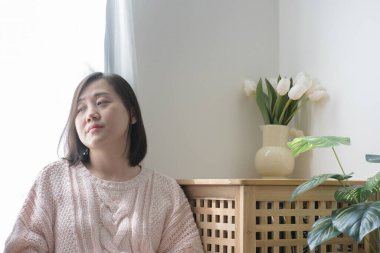 Asyalı kadın kitap okuyor ve evde dinleniyor.