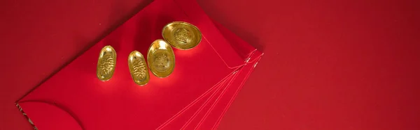 web banner flatlay design for chinese new year concept with red envelope and gold on red background