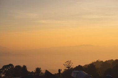 travel and people activity concept with twilight sky before sunrise with mountain and fog on foreground