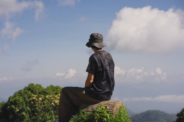 Manzara ve seyahat konsepti yalnız başına çalışan bir adam ve gün batımını ve alacakaranlık gökyüzünü dağ katmanıyla görüyor.