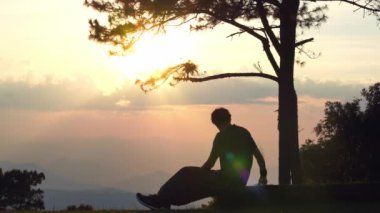 landscape and travel concept with solo freelancer man sit on wooden and use tablet work from outdoor with layer of mountain background