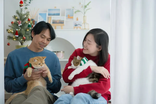 wellness at home concept with asian couple happy decorate house and play with cat at living room