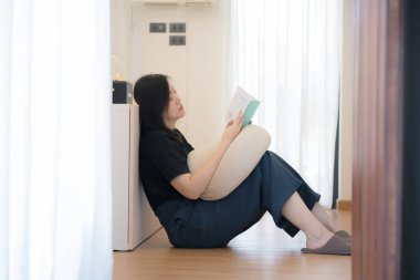 Asyalıların sağlık ve refah anlayışı oturma odasında oturup rahatlamak ve okumak.