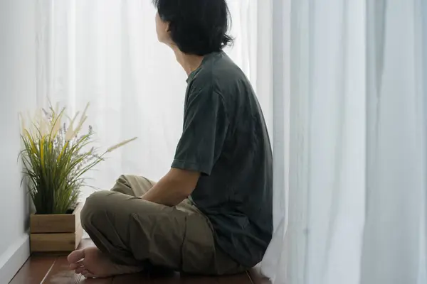 wellness and wellbeing concept with asian man sit and relax in livingroom