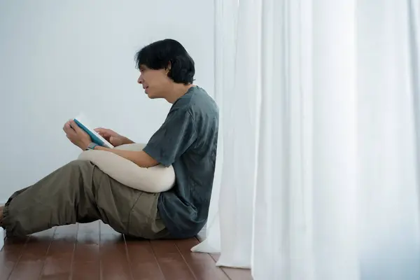 wellness and wellbeing concept with asian man sit and relax and read in livingroom