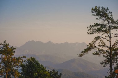 Günbatımı ve alacakaranlık gökyüzü ve dağ katmanıyla manzara ve seyahat kavramı
