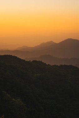 Doğa turuncu gökyüzü ve gün doğumuyla birlikte dağ katmanıyla seyahat ediyor.