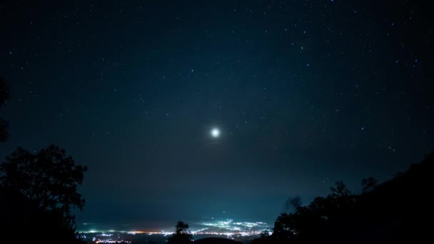 旅行と人々のアクティビティコンセプト 山の背景の層を持つ都市からの照明と夜のタイムラプス星 — ストック動画