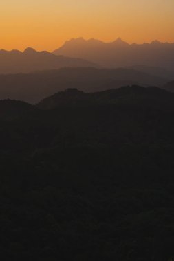 Doğa turuncu gökyüzü ve gün doğumuyla birlikte dağ katmanıyla seyahat ediyor.