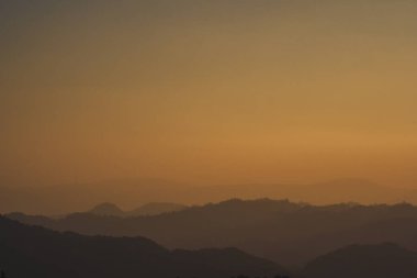 Günbatımı ve alacakaranlık gökyüzü ve dağ katmanıyla manzara ve seyahat kavramı