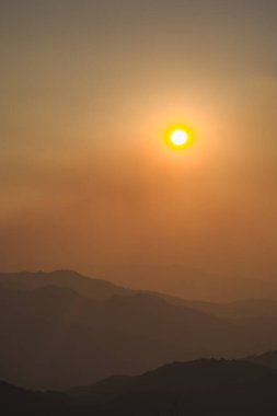Günbatımı ve alacakaranlık gökyüzü ve dağ katmanıyla manzara ve seyahat kavramı