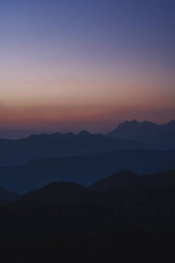 Doğa turuncu gökyüzü ve gün doğumuyla birlikte dağ katmanıyla seyahat ediyor.