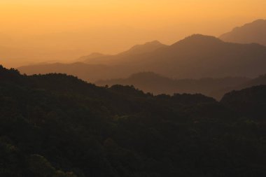 Doğa turuncu gökyüzü ve gün doğumuyla birlikte dağ katmanıyla seyahat ediyor.