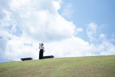 Yalnız kadın mutlu ve bulutlu bir geçmişle yaz yolculuğunun tadını çıkarıyor.