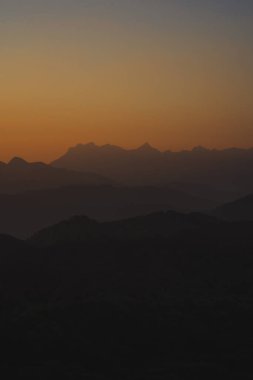 Doğa turuncu gökyüzü ve gün doğumuyla birlikte dağ katmanıyla seyahat ediyor.