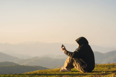 Doğa yalnız bir adamla seyahat eder rahatlar ve dağ tabakasıyla güneşin doğuşunu seyreder.