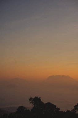 travel and people activity concept with twilight sky before sunrise with mountain and fog on foreground