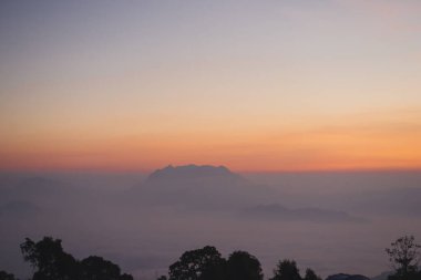 travel and people activity concept with twilight sky before sunrise with mountain and fog on foreground