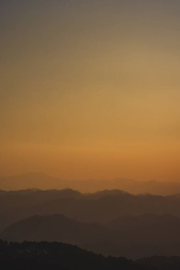 Günbatımı ve alacakaranlık gökyüzü ve dağ katmanıyla manzara ve seyahat kavramı