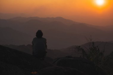 peyzaj ve seyahat konsepti yalnız başına serbest çalışan bir adamla rahatlamak ve dağın tepesinde köpekle oynamak ve dağ tabakası ile gün batımı