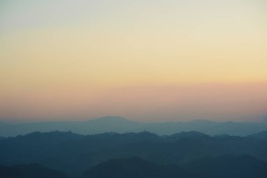 Günbatımı ve alacakaranlık gökyüzü ve dağ katmanıyla manzara ve seyahat kavramı