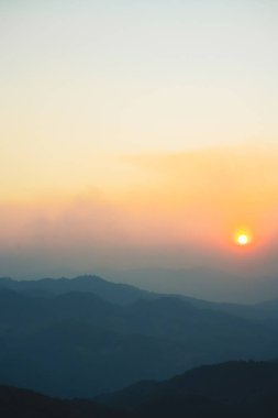 Günbatımı ve alacakaranlık gökyüzü ve dağ katmanıyla manzara ve seyahat kavramı
