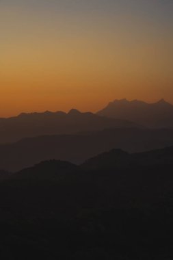 Doğa turuncu gökyüzü ve gün doğumuyla birlikte dağ katmanıyla seyahat ediyor.