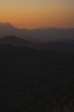 Doğa turuncu gökyüzü ve gün doğumuyla birlikte dağ katmanıyla seyahat ediyor.