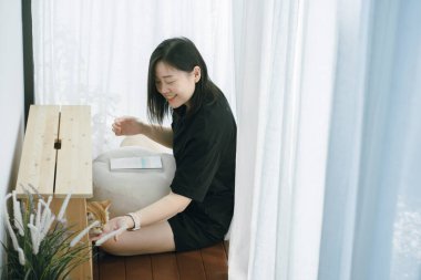 Kitap okurken ve oturma odasında İngiliz kedisiyle oynarken ev sahibiyle evcil hayvan bakımı kavramı