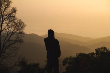 İnsanlarla manzara ve seyahat konsepti sabah gündoğumunu, dağ katmanını ve ormanlı sisi görün.
