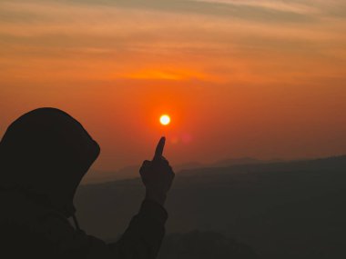 Solo gezgin poz verir ve gündoğumunda güneşle fotoğraf çeker.