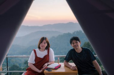 Asyalı çift, balayı seyahatleri ve dağ geçmişiyle rahatlar.