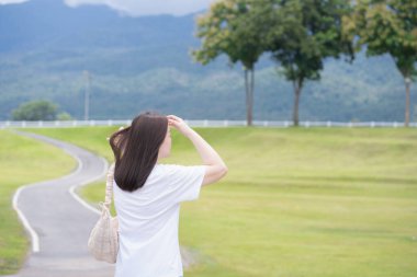Rahatlayın ve sağlığınıza dikkat edin. Bir kadın yağmur mevsiminde bahçede ve Chiangmai Tayland 'da yolda yürüyor.
