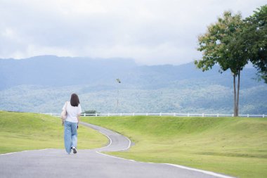 Rahatlayın ve sağlığınıza dikkat edin. Bir kadın yağmur mevsiminde bahçede ve Chiangmai Tayland 'da yolda yürüyor.