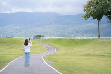 Rahatlayın ve sağlığınıza dikkat edin. Bir kadın yağmur mevsiminde bahçede ve Chiangmai Tayland 'da yolda yürüyor.