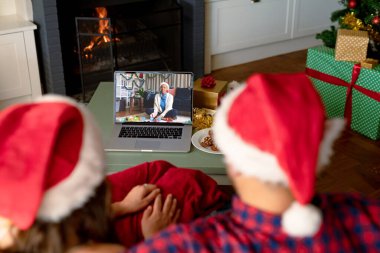 Kafkasyalı çift, Afrikalı Amerikalı bir kadınla Noel 'de görüntülü görüşme yapıyor. İletişim teknolojisi ve noel, dijital kompozit görüntü.