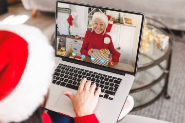 Kafkasyalı bir kadın, Kafkasyalı bir kadınla Noel 'de görüntülü görüşme yapıyor. İletişim teknolojisi ve noel, dijital kompozit görüntü.