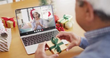 Kıdemli melez adam Afrikalı Amerikalı bir kadınla yılbaşı videosu çekiyor. İletişim teknolojisi ve noel, dijital kompozit video.