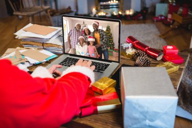 Afrika kökenli Amerikan ailesiyle Noel 'de görüntülü konuşma yapan son sınıf beyaz adam. İletişim teknolojisi ve noel, dijital kompozit görüntü.