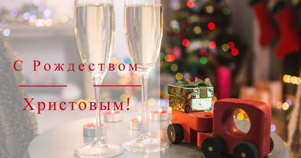 Composite image of christmas wishes with gifts and decoration in background at home, copy space. Orthodox christmas, greeting, text, tradition, non-western script, winter holiday.