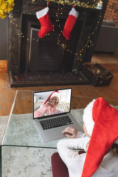 白人女性はシニアアフリカ系アメリカ人女性とクリスマスビデオ通話をしている 通信技術とクリスマス デジタル複合画像 — ストック写真