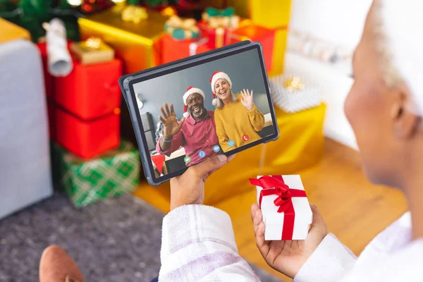 非洲裔美国妇女有圣诞视频通话与资深不同的夫妇 通信技术和圣诞节数字合成图像 — 图库照片