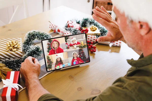 一个高年级的高加索人 带着各种各样的孩子打圣诞视频电话 通信技术和圣诞节数字合成图像 — 图库照片