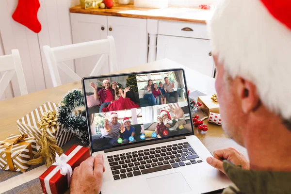 多様な人々とクリスマスビデオ通話を持つシニア白人男性 通信技術とクリスマス デジタル複合画像 — ストック写真