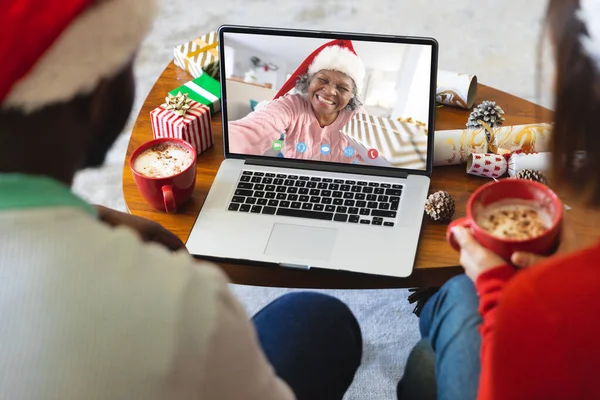 不同的夫妇有圣诞节视频电话与资深的非洲裔美国女人 通信技术和圣诞节数字合成图像 — 图库照片
