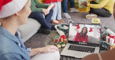 Noel Baba şapkalı, dizüstü bilgisayarlı birçok arkadaşın Noel 'de bir kadınla yaptığı görüntülü konuşma. Noel, şenlik, gelenek ve kutlama konsepti dijital olarak oluşturuldu.