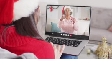 Noel Baba şapkalı beyaz bir kadının Noel 'de kadınla yaptığı görüntülü konuşma. Noel, şenlik, gelenek ve kutlama konsepti dijital olarak oluşturuldu.