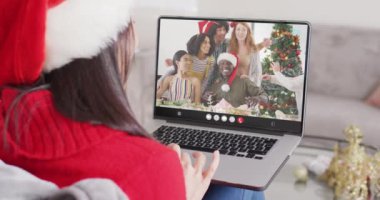 Noel Baba şapkalı beyaz bir kadının Noel 'de arkadaşlarıyla yaptığı görüntülü konuşma. Noel, şenlik, gelenek ve kutlama konsepti dijital olarak oluşturuldu.
