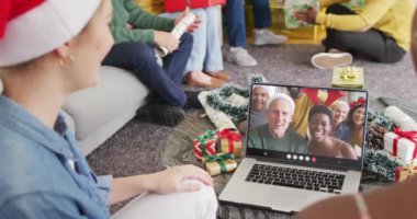 Çeşitli arkadaş grupları Noel 'de farklı insanlarla görüntülü görüşme yapıyor. İletişim teknolojisi ve noel, dijital kompozit video.